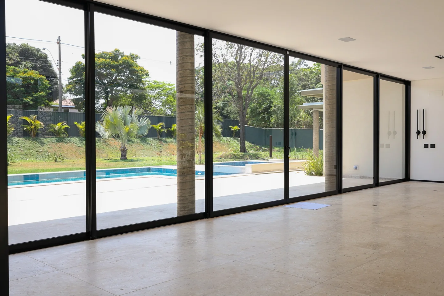 Esquadrias pretas de alumínio integrando sala e jardim
